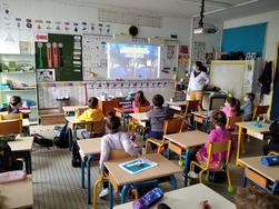 Classe d'écoliers devant une projection sur un tableau blanc